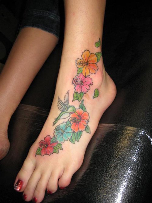 Awesome Colored Flowers And Humming Bird Tattoo On Left Foot