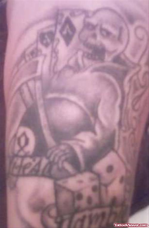 Grey Ink Skull And Dice Gambling Tattoo On Arm