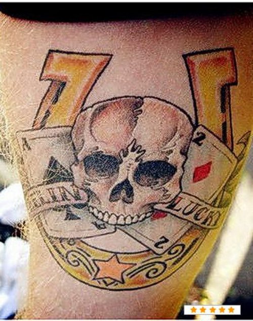 Grey Ink Skull And Horseshoe Gambling Tattoo On Bicep