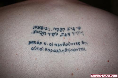 Greek Script Tattoo On Upperback