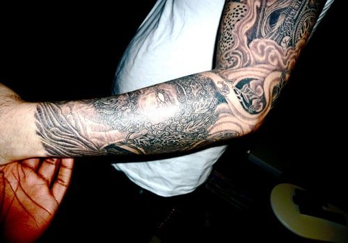 Grey Ink Greek Tattoo On Man Left Sleeve