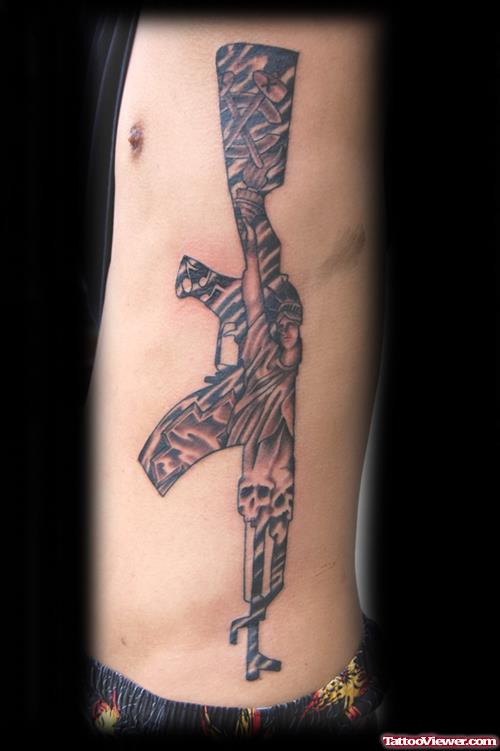 Grey Ink Gun Tattoo On Side Rib