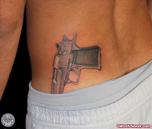 Grey Ink Gun Tattoo On Man Lowerback