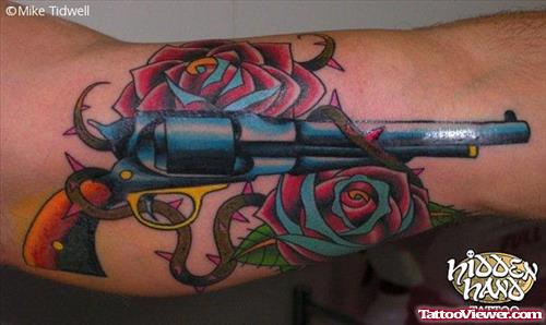 Color Rose Flowers And Gun Tattoo On Bicep
