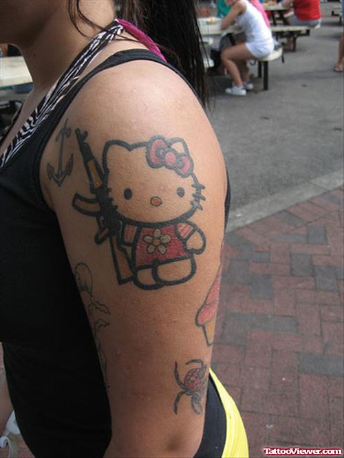 Colored Hello Kitty With Gun Tattoo On Left Shoulder