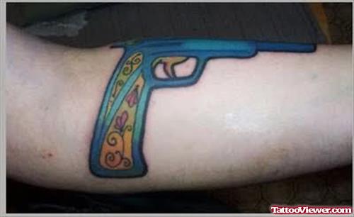 Blue ink Gun Tattoo On Arm