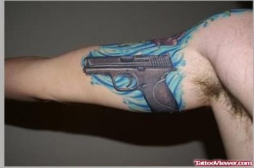 Colored Gun Tattoo On Muscles