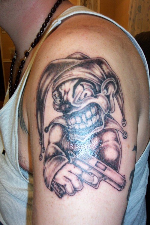 Grey Ink Joker With Gun Tattoo On Left Half Sleeve