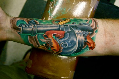 Beautiful Colored Gun Tattoo On Sleeve
