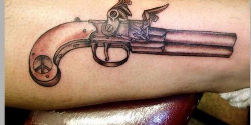 Grey Ink Gun Tattoo On Arm