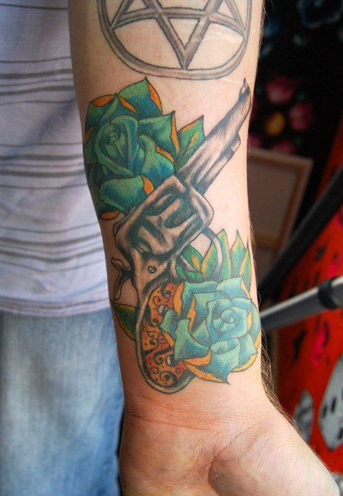 Blue Rose Flowers and Gun Tattoo On Left Arm