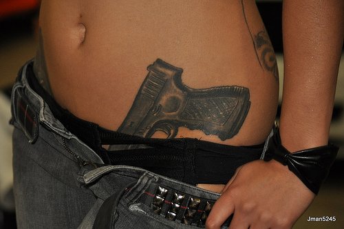 Dark Ink Gun Tattoo On Left Hip