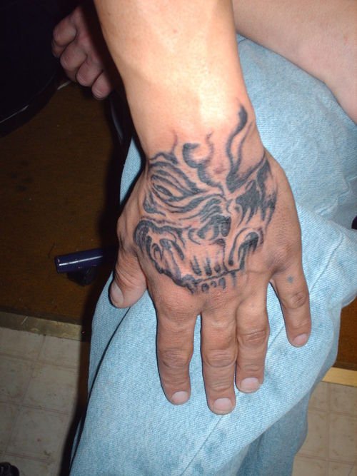 Attractive Grey Ink Skull Hand Tattoo