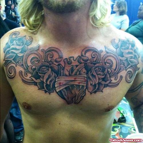 Grey Flowers And Human Heart Tattoo On Man Chest