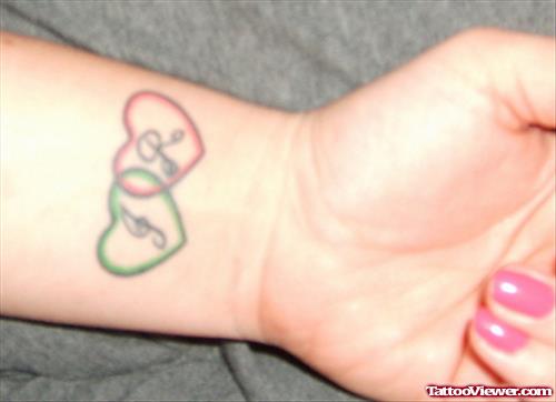 Green And Red Heart Tattoos On Wrists