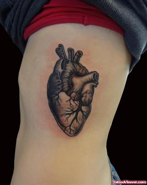 Grey Ink Heart Tattoo On Rib