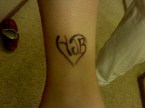Black Ink Heart Tattoo On Leg