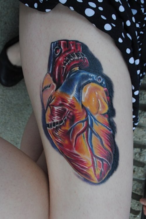 Colored Human Heart Tattoo On Thigh