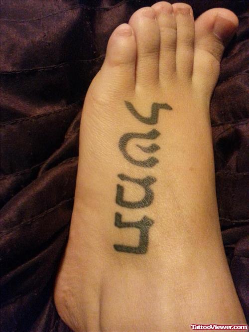 Black Ink Hebrew Tattoo On Left Foot