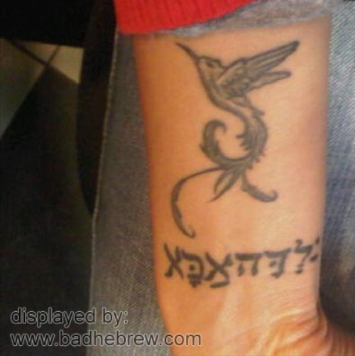 Grey Ink Flying Phoenix Hebrew Tattoo On Forearm