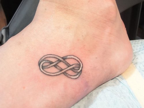 Grey Ink Infinity Tattoo On Left Foot