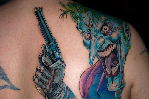 Colored Jester With Gun Tattoo On Back Shoulder