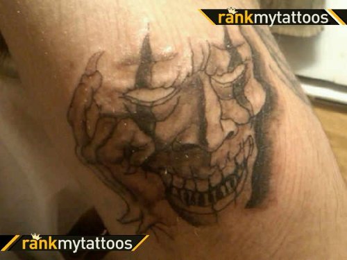 Grey Ink Jester Tattoo On Bicep