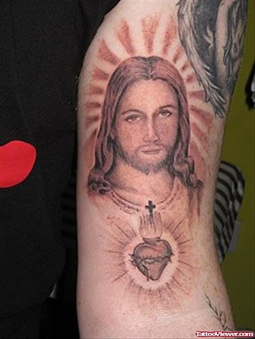 Grey Ink Heart And Jesus Tattoo On Left Bicep