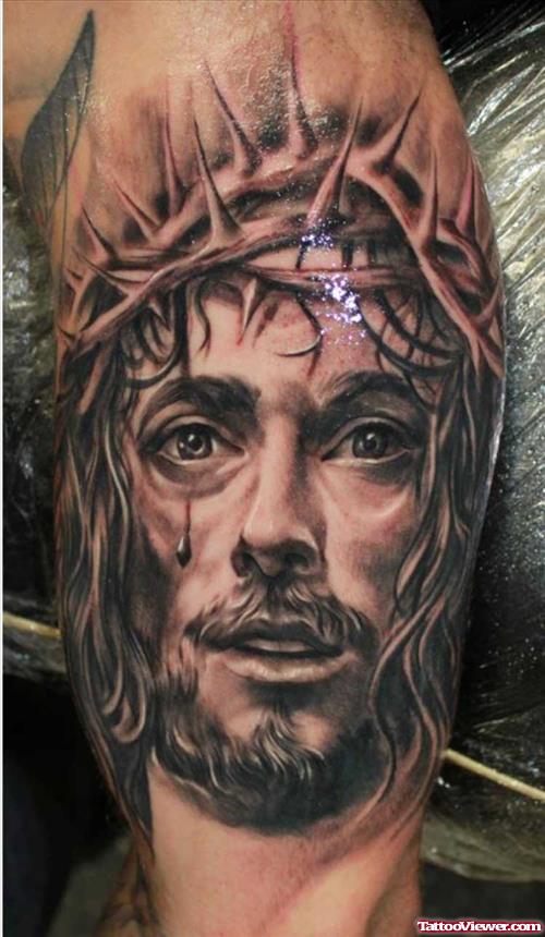 Grey Ink Jesus Head Tattoo On Biceps