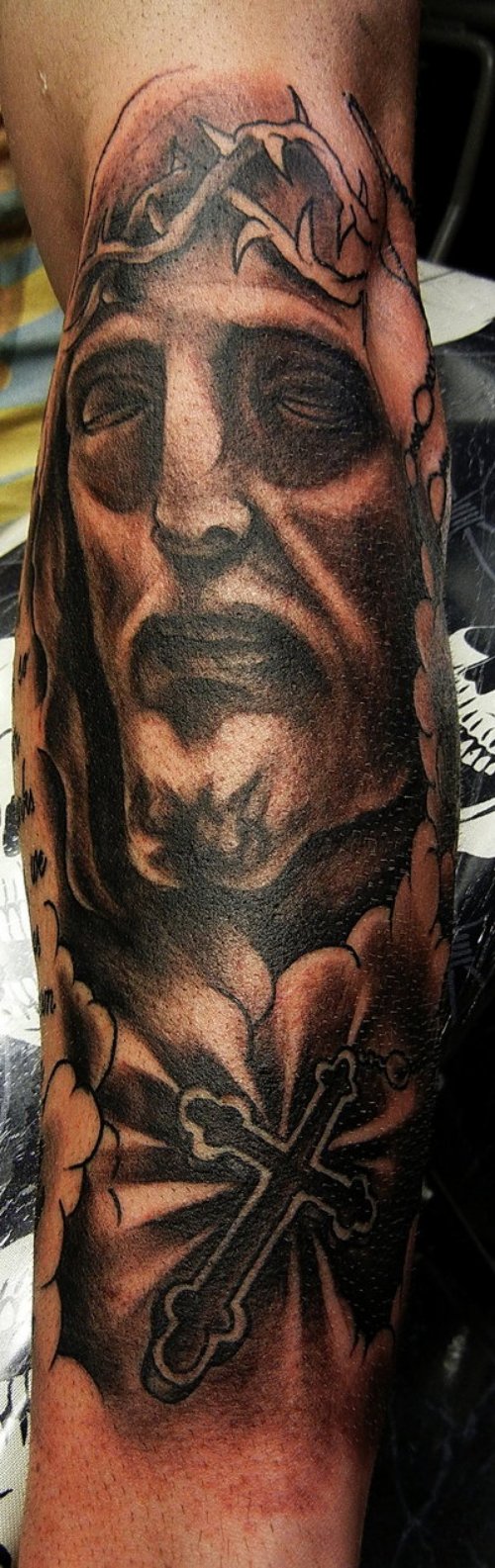 Black Cross And Jesus Head Tattoo On Arm