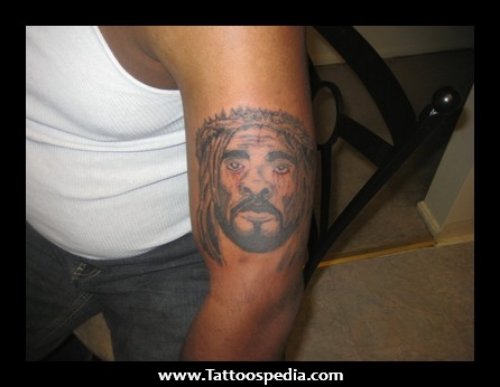 Grey Ink Jesus Head Tattoo On Left Bicep