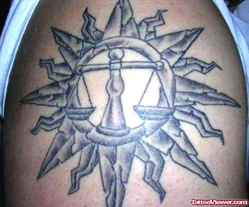 Grey Ink Tribal Sun And Balance Justice Tattoo On Shoulder