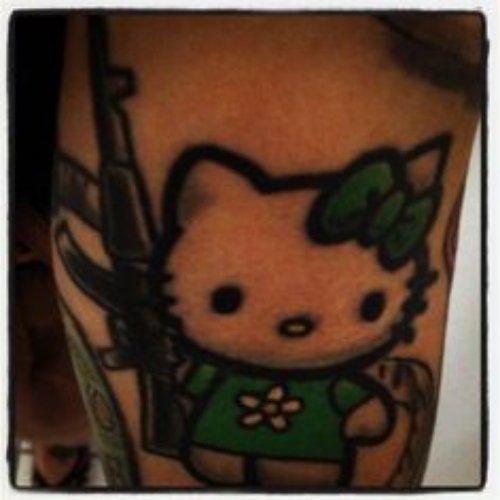 Green Ink Hello Kitty With Gun Tattoo