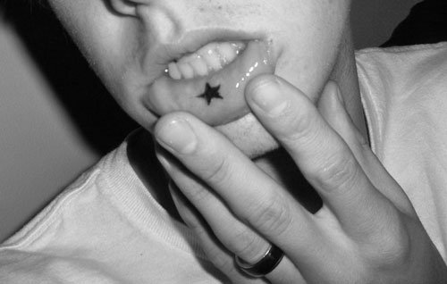 Small Black Star Inner Lip Tattoo