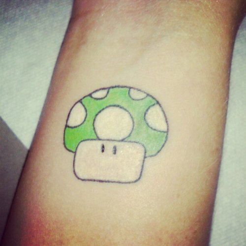 Green Ink Mario Mushroom Tattoo On Arm