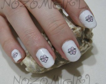 Small Flowers On White Nails Tattoos