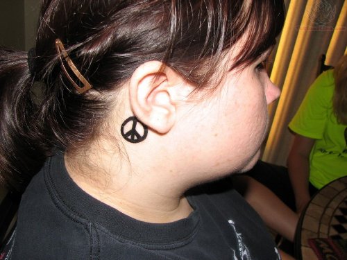 Peace Sign Tattoo On Girl Behind Ear