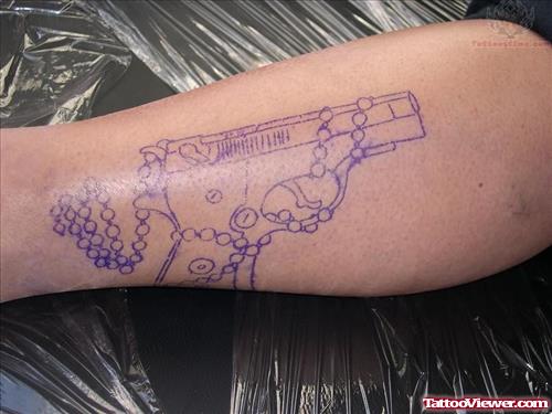 Blue Ink Pistol Tattoo On Arm
