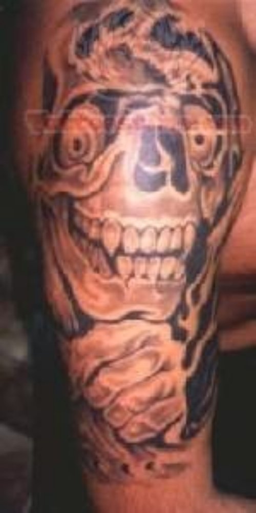 Smiling Skull Tattoo On Biceps