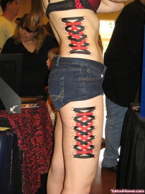 Red And Black Ink Corset Tattoo On Hip And Thigh