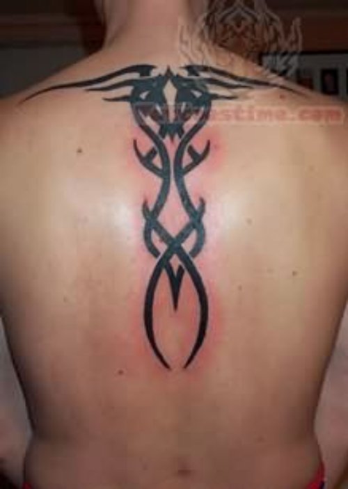 Shining Black Tribal Tattoo On Upper Back
