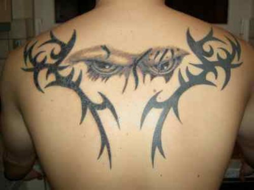 Grey Ink Eyes And Tribal Tattoo On Back