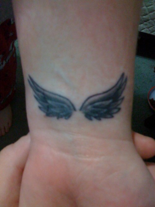 Black Ink Small angel Wings Tattoo On Wrist
