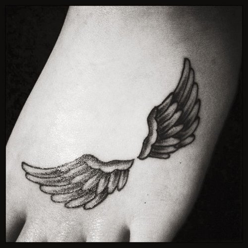 Grey Ink Wings Tattoo On Foot