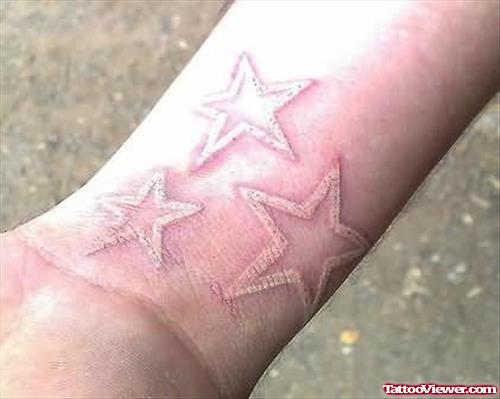 White Ink Stars Tattoo On Wrist